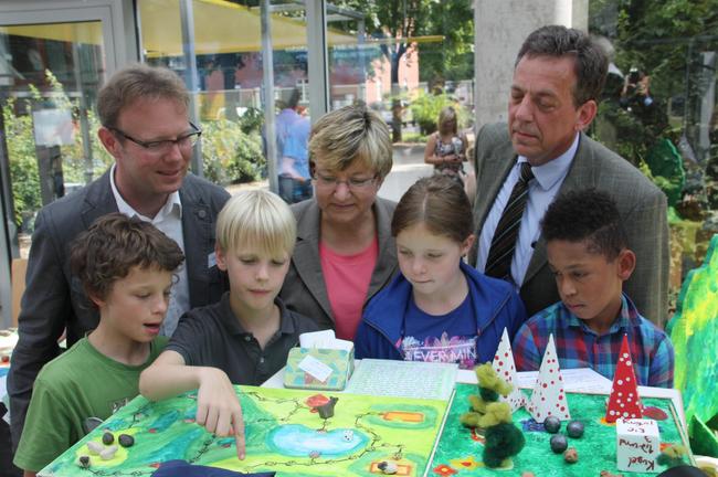 Frank Corleis (l.), Leiter des SCHUBZ Lüneburg, Frauke Heiligenstadt (m.), Niedersächsische Kultusministerin und Schirmherrin des Ideenwettbewerbs und Helmut Dammann-Tamke (r.), Präsident der Landesjägerschaft Niedersachsen, lassen sich einen Projektbeitrag erklären. (Foto: Schubz)