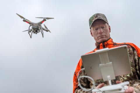 Jäger mit Drohne im Flug